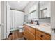 Bright bathroom featuring a wood vanity, updated fixtures, and a shower with a full curtain at 1114 Pennsylvania St, Columbus, IN 47201