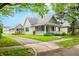 Inviting home with a quaint front porch, a driveway, and a lush green lawn, offering curb appeal at 1114 Pennsylvania St, Columbus, IN 47201