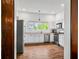 Well-lit kitchen with white cabinets, stainless steel appliances, and wood-look floors offers a modern design at 1114 Pennsylvania St, Columbus, IN 47201