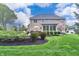 View of the house with a backyard featuring green grass, patio furniture and lovely landscaping at 11233 Rockingham Cir, Fishers, IN 46037
