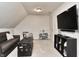 A bonus room with TV, play kitchen, couch and coffee table offers space to relax and play at 11233 Rockingham Cir, Fishers, IN 46037