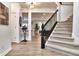 Inviting entryway with hardwood floors, staircase, and a view into the living spaces at 11233 Rockingham Cir, Fishers, IN 46037