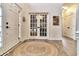 Bright entryway with hardwood floors, a round rug, and French doors leading to an office at 11233 Rockingham Cir, Fishers, IN 46037