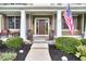 Inviting front entrance with covered porch, American flag, and decorative planters at 11233 Rockingham Cir, Fishers, IN 46037