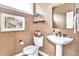 Stylish powder room with textured wallpaper, pedestal sink, and elegant mirror at 11233 Rockingham Cir, Fishers, IN 46037