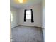 A simple bedroom with carpet floors and a view to the outside at 1205 N Gibson Ave, Indianapolis, IN 46219