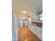 This kitchen features white cabinets, wood floor, modern appliances and plenty of counter space at 1205 N Gibson Ave, Indianapolis, IN 46219