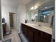 Bathroom featuring double sink vanity with dark wood cabinets and large mirror, plus a decorative rug at 1221 Malbec Cir, Westfield, IN 46074