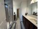 Bright bathroom featuring double sinks, a walk-in shower with glass door, and wood-look accent wall at 1221 Malbec Cir, Westfield, IN 46074