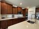 Well-lit kitchen with granite countertops, dark wood cabinetry, and stainless steel appliances at 1221 Malbec Cir, Westfield, IN 46074