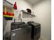 Well-equipped laundry room with modern washer and dryer units and storage shelves at 1221 Malbec Cir, Westfield, IN 46074