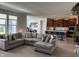 Open-concept living room with a large sectional couch that seamlessly connects to a modern kitchen at 1221 Malbec Cir, Westfield, IN 46074