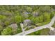 Aerial view of a home with a spacious driveway, lush landscaping, a neighboring house, and a tennis court in the background at 13 Ridgeline Dr, Brownsburg, IN 46112