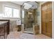 Modern bathroom featuring a walk-in shower with skylight, stone tile, and wooden cabinets at 13 Ridgeline Dr, Brownsburg, IN 46112