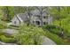 Aerial view of a charming brick home showcasing professional landscaping, a winding driveway, and mature flowering trees at 13 Ridgeline Dr, Brownsburg, IN 46112