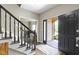 Inviting foyer with a staircase and black railing, offering a glimpse of the front porch with brickwork at 13 Ridgeline Dr, Brownsburg, IN 46112