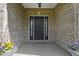 Welcoming front entrance featuring a black front door flanked by glass side panels and potted flowers on each side at 13 Ridgeline Dr, Brownsburg, IN 46112