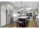 Modern kitchen featuring white cabinets, a large island, stainless steel appliances, and hardwood floors at 13 Ridgeline Dr, Brownsburg, IN 46112