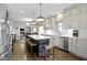 Well-lit kitchen with stainless appliances, a center island with seating, and views into the Gathering room at 13 Ridgeline Dr, Brownsburg, IN 46112