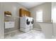 Well-equipped laundry room with modern washer and dryer, utility sink, and ample storage at 13 Ridgeline Dr, Brownsburg, IN 46112