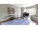 Sunlit living room featuring a piano, neutral walls, a large window, and hardwood floors at 13 Ridgeline Dr, Brownsburg, IN 46112