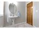 Stylish powder room with a pedestal sink, decorative mirror, and modern fixtures at 13 Ridgeline Dr, Brownsburg, IN 46112