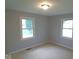 A cozy bedroom features neutral walls, carpeting, and ample natural light from two windows at 1314 Brookside S Dr, Columbus, IN 47201
