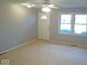 Bright living room with neutral carpet, a ceiling fan, and large windows at 1314 Brookside S Dr, Columbus, IN 47201