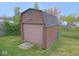 Exterior view of large shed with functional garage door in a fenced yard at 1314 Brookside S Dr, Columbus, IN 47201