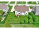 Aerial view displays a backyard with a patio area, play structure, and a well-maintained lawn with trees at 13728 Oliver Ln, Carmel, IN 46074