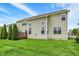 Lush backyard featuring a well-maintained lawn, mature trees, and a wooden deck perfect for outdoor living at 13728 Oliver Ln, Carmel, IN 46074