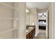 Bathroom with shelving, double vanity with granite countertop, and view into bedroom at 13728 Oliver Ln, Carmel, IN 46074