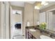 Bathroom featuring double vanity with granite countertop and view into bedroom at 13728 Oliver Ln, Carmel, IN 46074