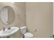 Cozy half-bath features a pedestal sink, round mirror, and neutral walls at 13728 Oliver Ln, Carmel, IN 46074