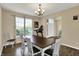Well-lit dining area with hardwood floors, a modern chandelier, and a large window view at 13728 Oliver Ln, Carmel, IN 46074