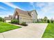 Charming two-story home featuring a three-car garage, well-manicured lawn, and a brick and siding facade at 13728 Oliver Ln, Carmel, IN 46074