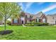 Inviting brick home features a lush green lawn and mature landscaping, creating a welcoming and attractive facade at 13728 Oliver Ln, Carmel, IN 46074