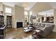 Spacious living room with vaulted ceilings, large windows, fireplace, and a comfortable leather sectional sofa at 13728 Oliver Ln, Carmel, IN 46074