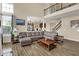 Bright living room with soaring ceilings, an open floor plan, wood floors, and comfortable leather furniture at 13728 Oliver Ln, Carmel, IN 46074