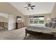 Comfortable main bedroom features plush carpet, a ceiling fan, and serene views from the three windows at 13728 Oliver Ln, Carmel, IN 46074