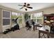 Functional home office with multiple windows, a ceiling fan, built-in shelving, and ample desk space at 13728 Oliver Ln, Carmel, IN 46074