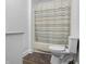 Clean bathroom featuring a toilet, shower with curtain, and neutral walls at 1401 E 24Th St, Muncie, IN 47302