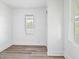 Bright bedroom featuring wood-look flooring, white walls, and multiple windows with blinds at 1401 E 24Th St, Muncie, IN 47302