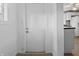 Hallway featuring white walls and a view of a kitchen with white cabinets and dark countertops at 1401 E 24Th St, Muncie, IN 47302