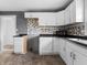 Galley kitchen featuring white cabinets, contrasting backsplash and vinyl flooring at 1401 E 24Th St, Muncie, IN 47302