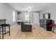 Well-lit living room with wood-look floors, a ceiling fan, and a view to the entry door at 1401 E 24Th St, Muncie, IN 47302