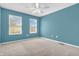 Bedroom with neutral carpet, two windows, a ceiling fan, and blue painted walls at 15329 Smithfield Dr, Westfield, IN 46074