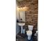 Stylish bathroom showcasing a pedestal sink, decorative mirror, and unique wood-paneled accent wall at 15406 Forest Glade Dr, Fishers, IN 46037
