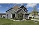 Attractive two-story home with gray siding, stone facade, manicured landscaping, and an attached two-car garage at 15406 Forest Glade Dr, Fishers, IN 46037