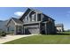 Charming two-story home with gray siding, stone accents, and an attached two-car garage at 15406 Forest Glade Dr, Fishers, IN 46037
